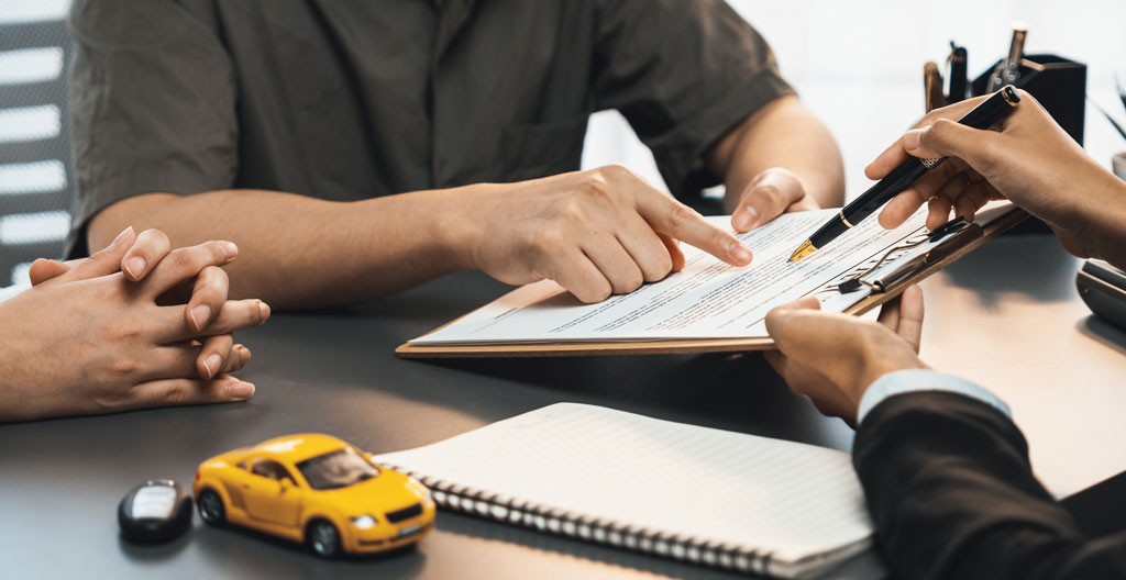 Gros plan sur une main tapant sur une calculatrice posée sur un bureau moderne avec des documents floutés en arrière-plan